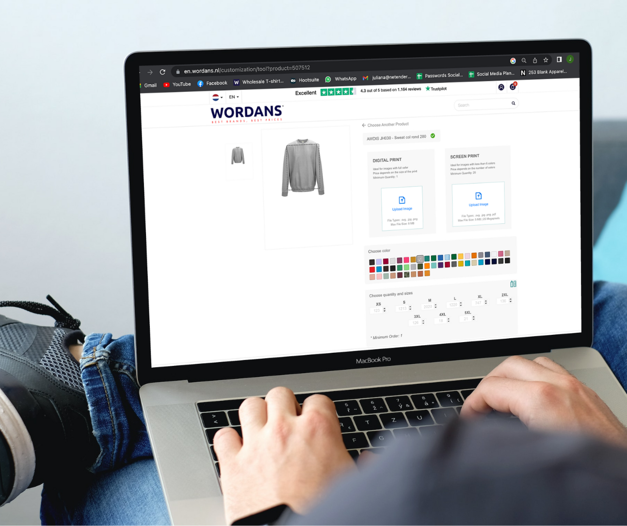 A guy working with his laptop customizing a sweatshirt in the Wordans website