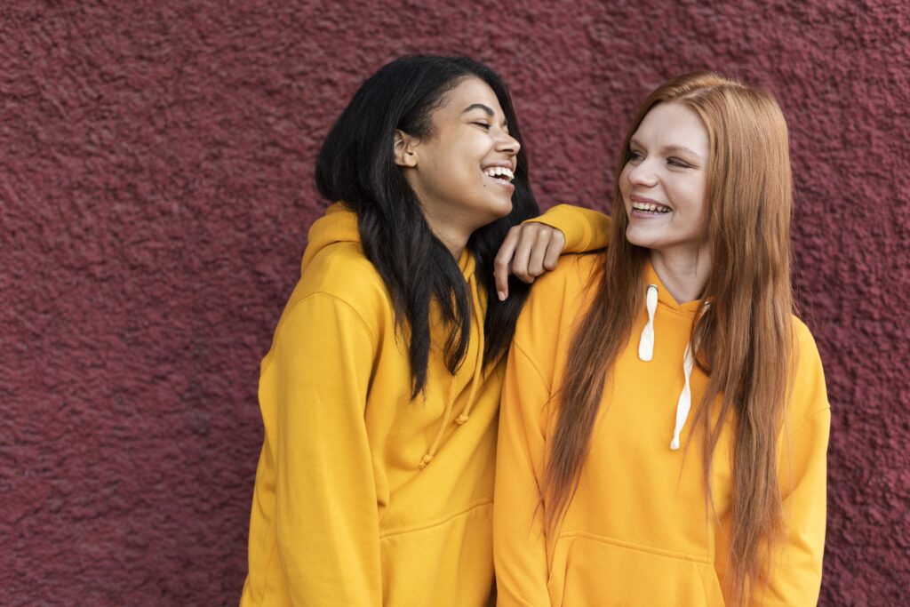 two girls wearing the same yellow hoodie