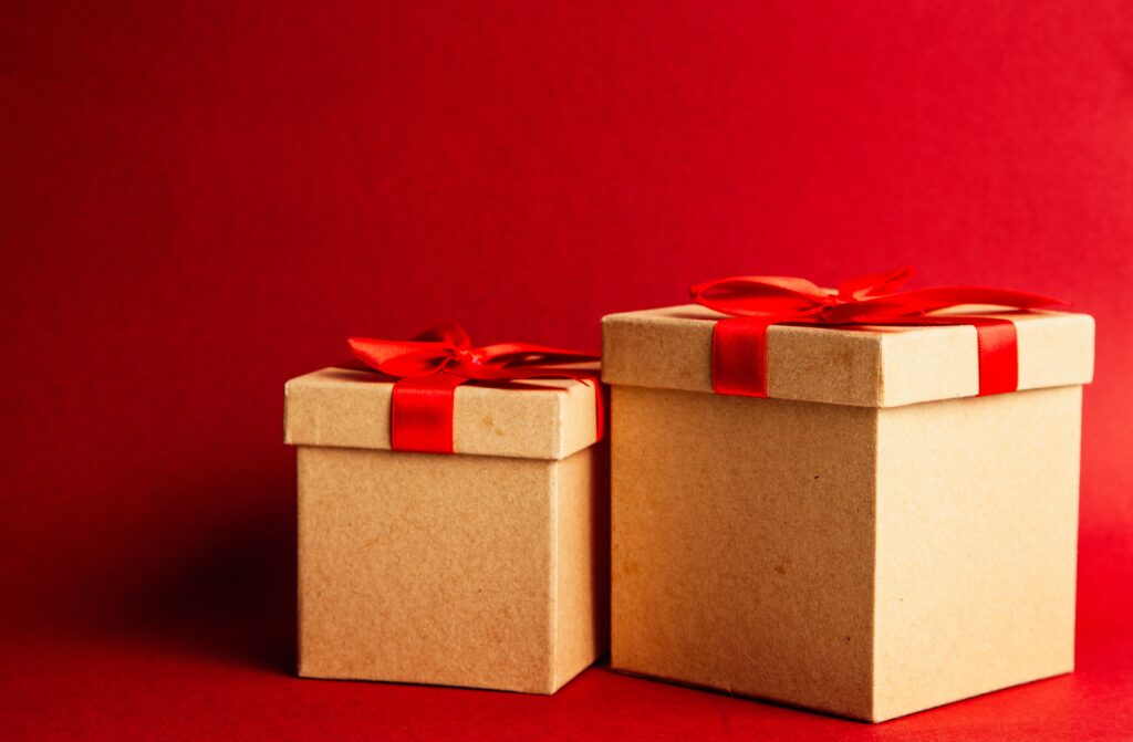 Two golden gift boxes on a red background