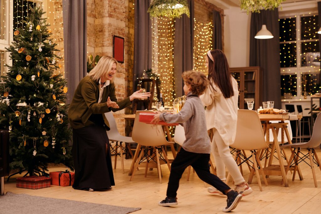 A boy runs to a woman, most likely his grandma, at Christmas