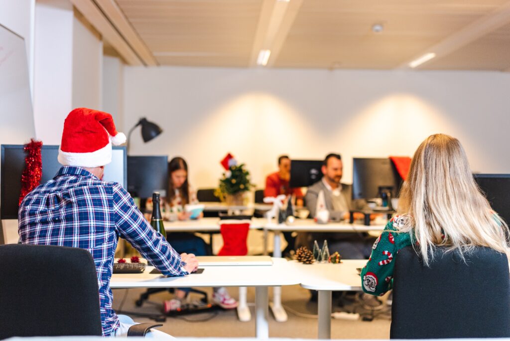 office workers at their desks during Christmas, with santa hats