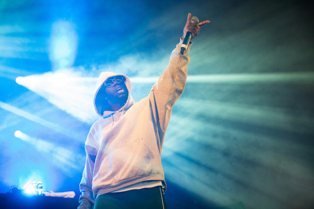 A rapper performs while wearing a hoodie