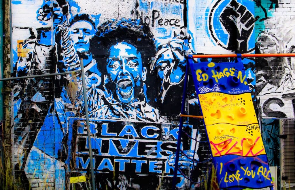 Graffiti depicts a woman in a hoodie, with the words 'black lives matter'