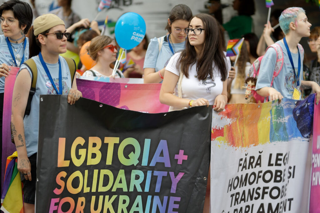 People at a Pride event with messages of support