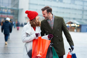 A couple smiling together with shopping bags in winter