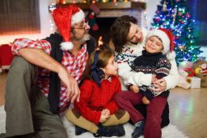 A family with young children opening presents together at Christmas.