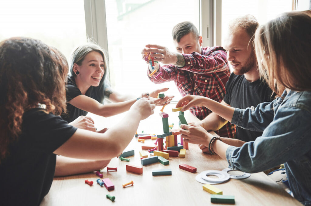 A group of people smiling while playing a board game